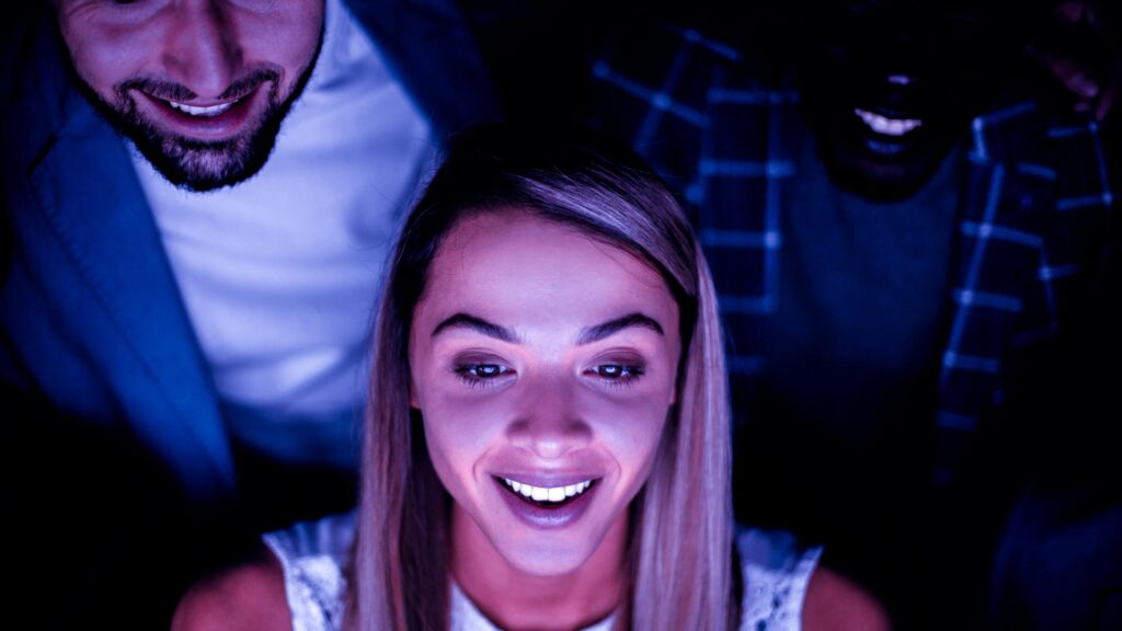 Nahaufnahme junger Angestellter die auf einen Computerbildschirm schauen.