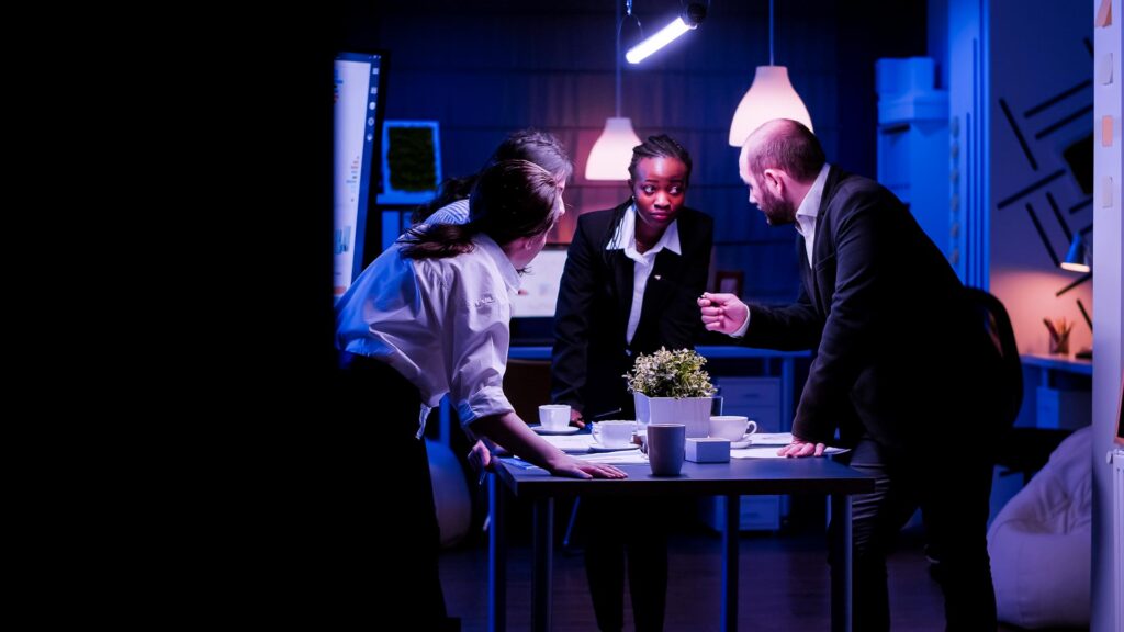 Diverse Geschäftsleute diskutieren über Management-Papierkram stehen am Konferenztisch arbeiten im Büro Tagungsraum. Multi-ethnische Teamarbeit Brainstorming Präsentation Ideen spät in der Nacht.