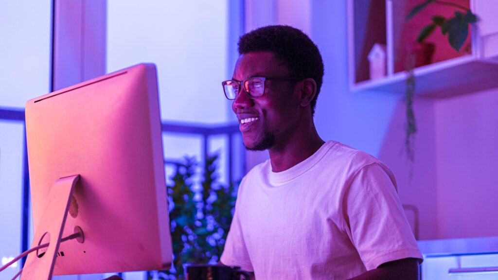 Happy smiling it specialist enjoy working from home on new remote project. Successful african web developer coding new program, website or software. Young freelance programmer on distance occupation